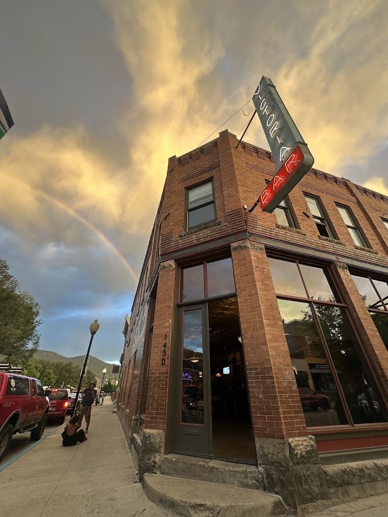 Corner bar with rainbow in the sky.