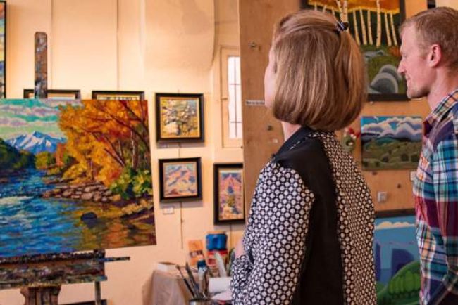 Two people viewing a painting in an art gallery in Salida, CO