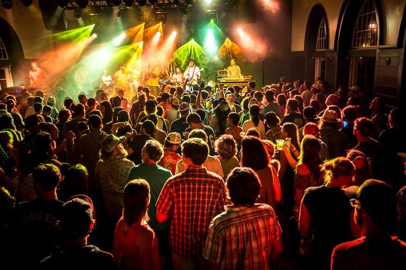 Crowded concert with colorful stage lights.