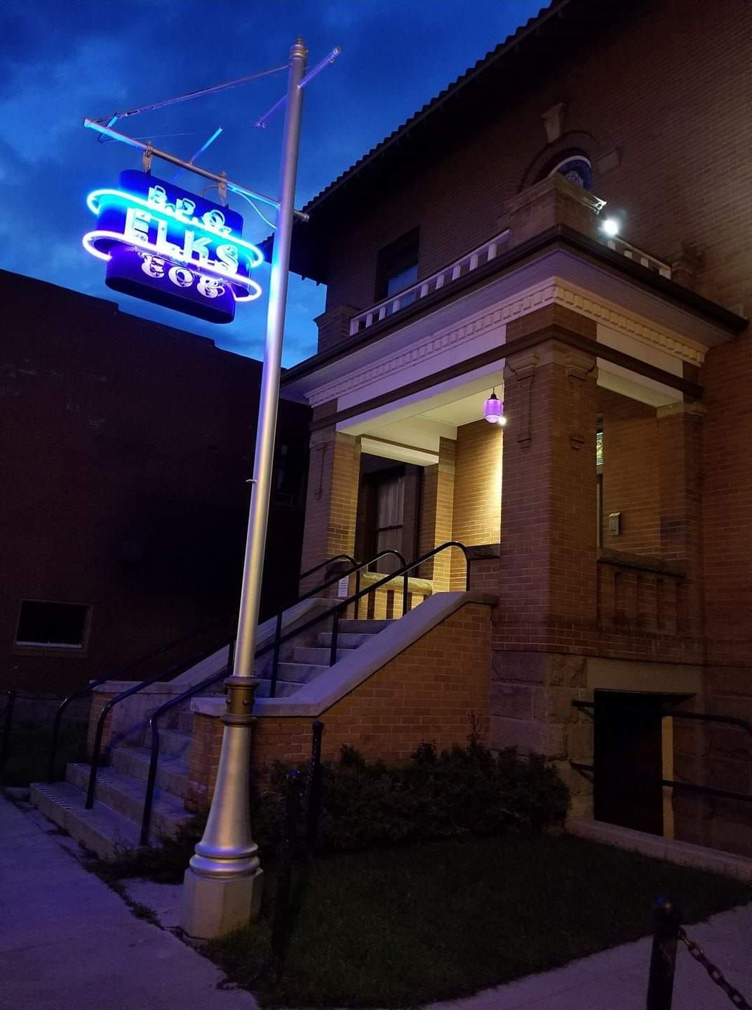 Neon Elks Lodge sign on brick building at night.